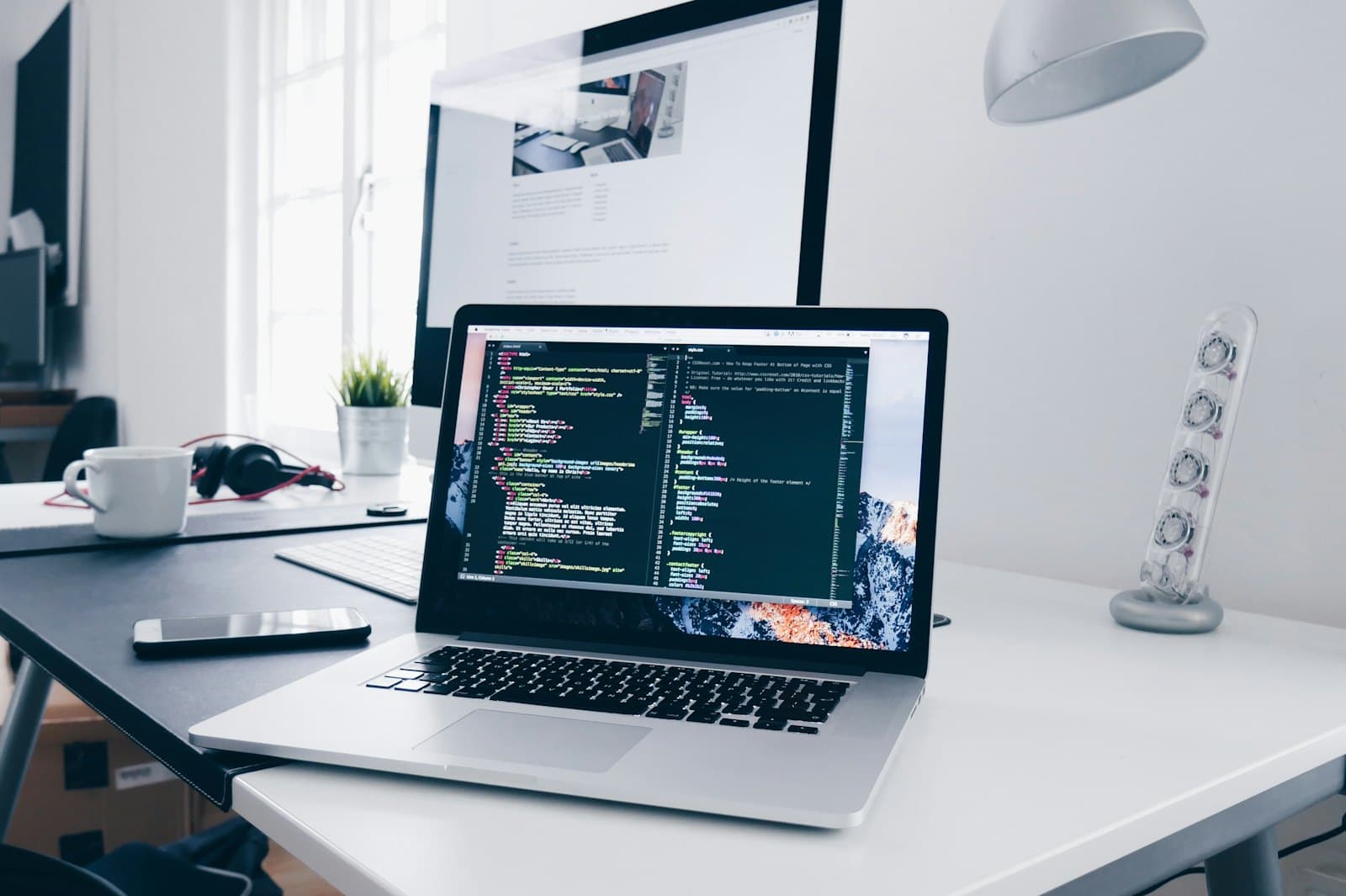 Laptop on a desk with source code on screen