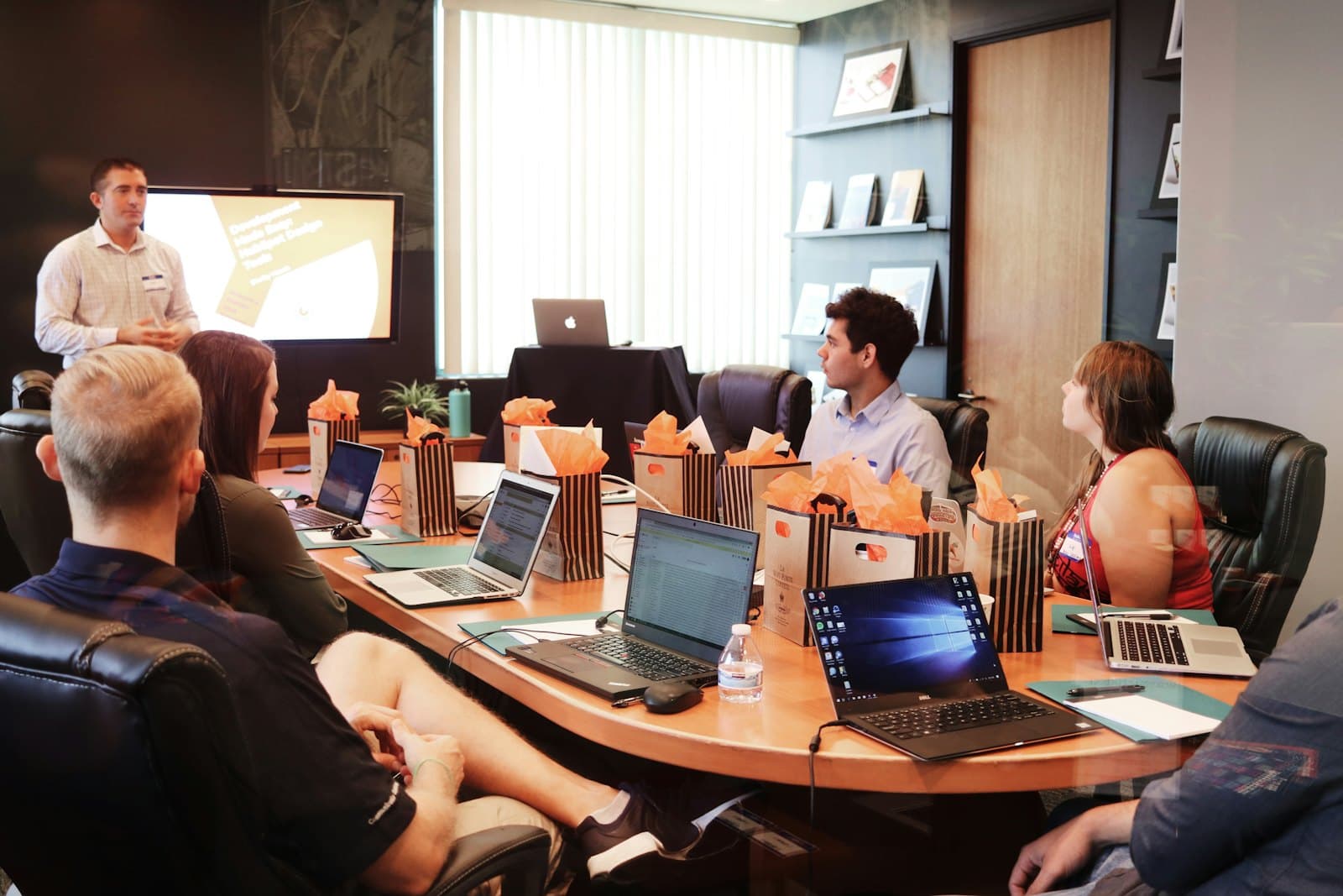 A working session around a conference table with laptops open